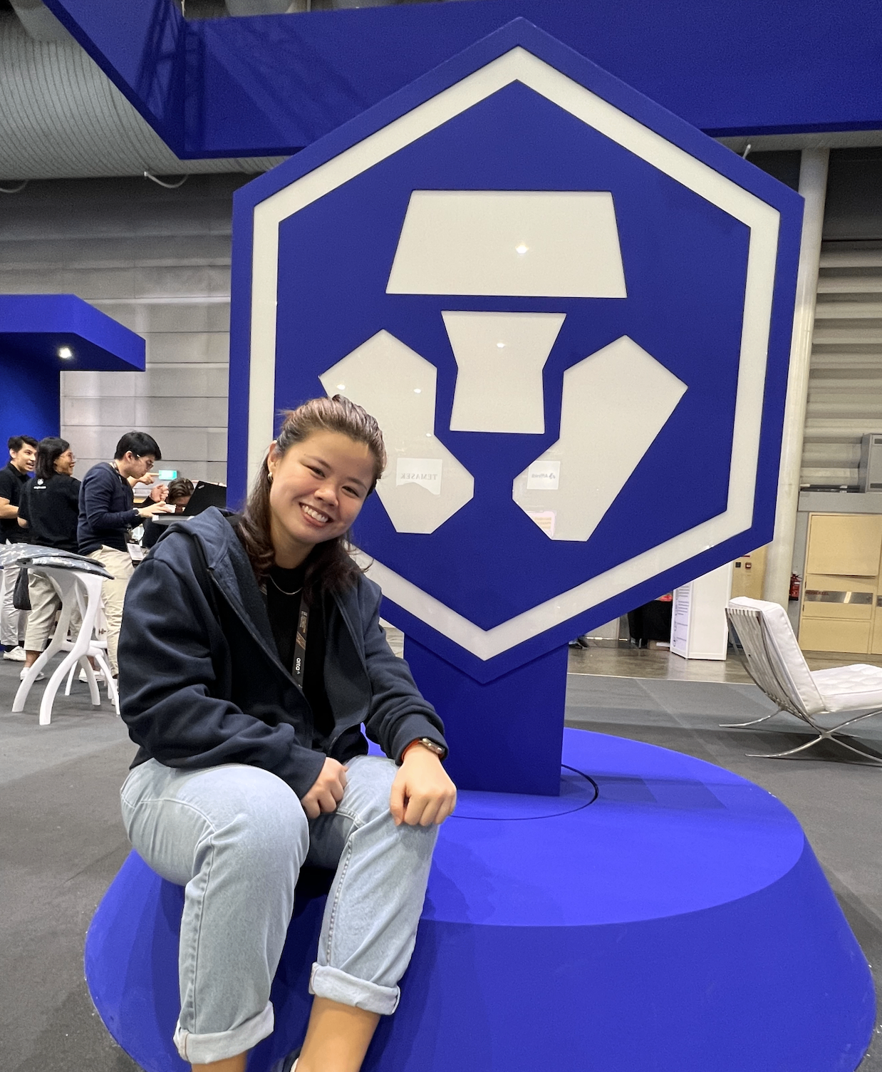 Mandy beside the Crypto.com logo at a company event